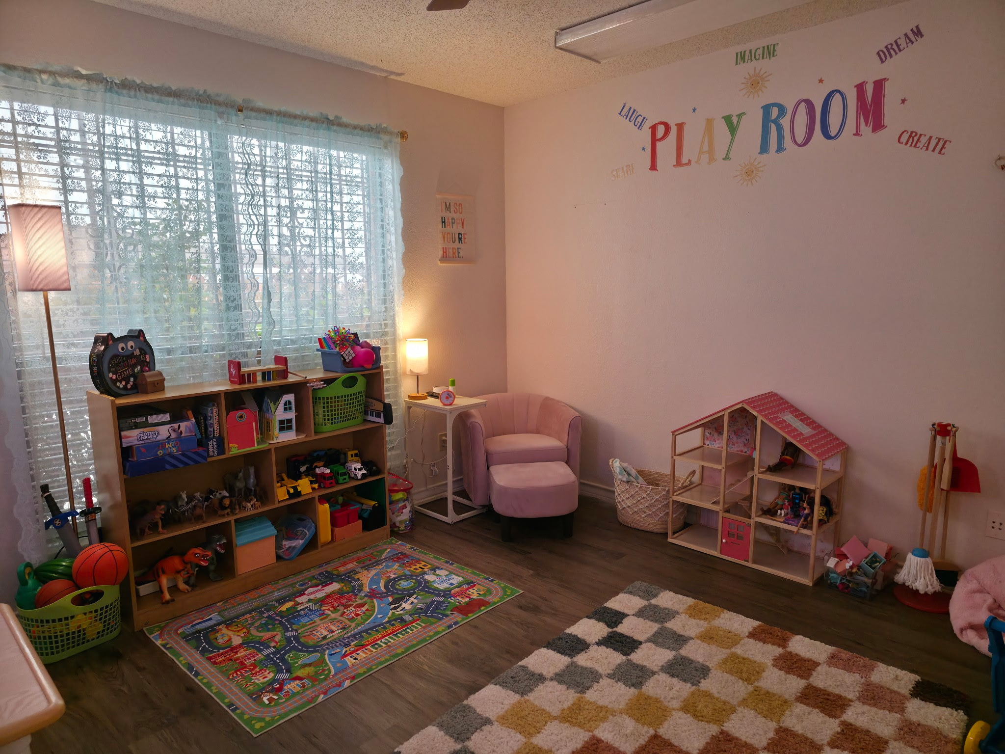 Play therapy room with toy kitchen, dollhouse, and soft seating