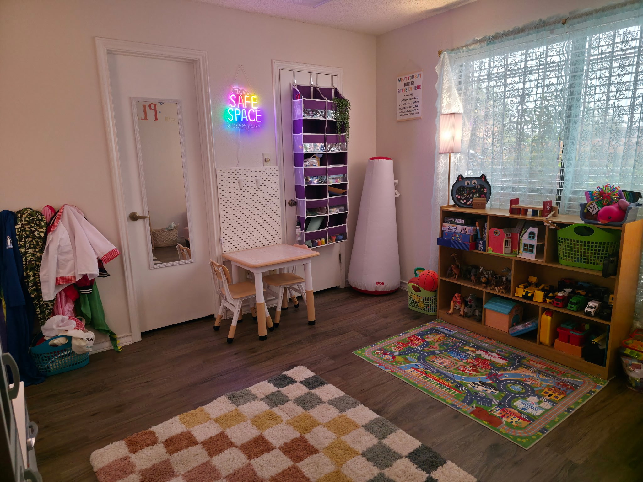 Play therapy room with toys, bookshelves, and a colorful rug