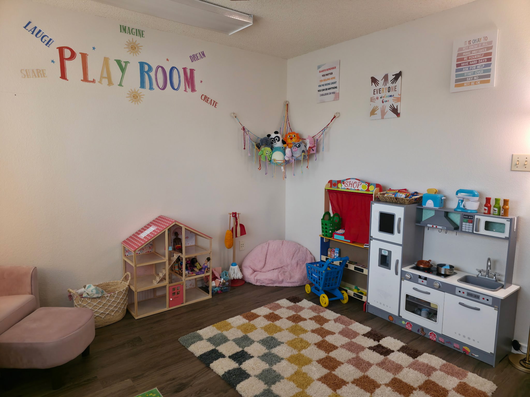Play therapy room with toys, bookshelves, and a colorful rug